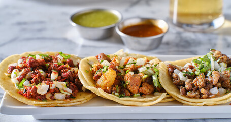 platter of mexican street tacos with carne asada, chorizo, and al pastor in corn tortillas