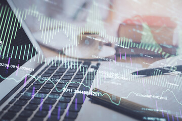 Double exposure of financial chart drawing and desktop with coffee and items on table background. Concept of forex market trading