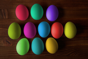Colorful eggs for Easter on a wooden table. View from above.