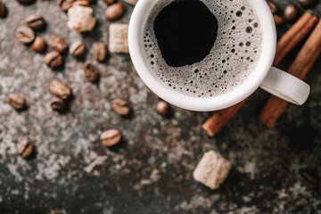 Coffee cup and coffee beans on dark stone background.