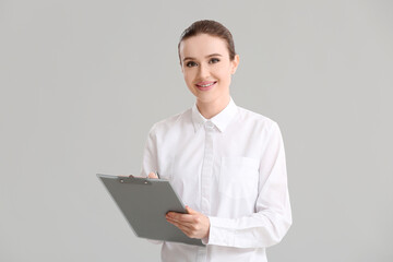 Young businesswoman on grey background