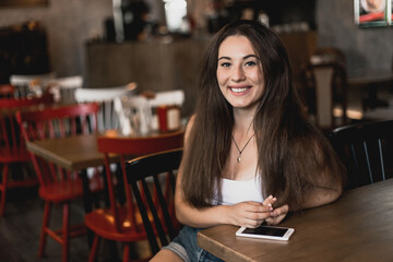 Beautiful woman posing for the camera sitting in a cafe.