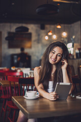 Business woman using tablet and drinking coffee in a cafe.