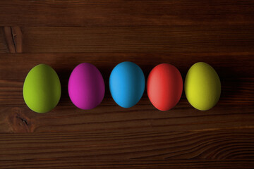 Colorful eggs for Easter on a wooden table. View from above.