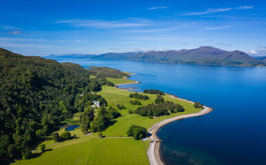 aerial image of loch linnhe on the west coast of the argyll and lochaber region of scotland near kentallen and duror showing calm blue waters and clear skies with green forest coast line