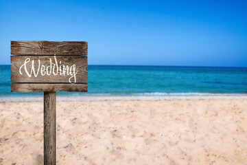 Wooden plaque with inscription Wedding on sandy beach, space for text