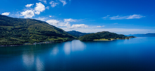 Obraz premium aerial image of loch linnhe on the west coast of the argyll and lochaber region of scotland near kentallen and duror showing calm blue waters and clear skies with green forest coast line