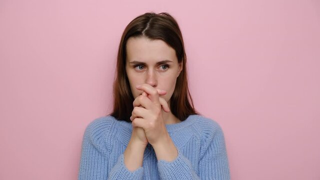 Worried brunette woman feeling nervous, thinking of breaking up or divorce, wears sweater, isolated on pink background. Anxious doubtful girl, suffering from depression, worrying about wrong decision