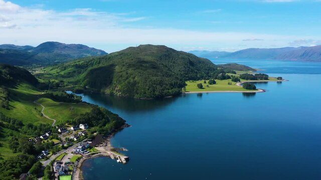 aerial footage of loch linnhe on the west coast of the argyll and lochaber region of the highlands of scotland on a clear blue sky summer day with calm waters and green forest coast line