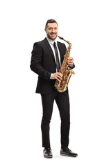 Man in a suit standing and holding a saxophone