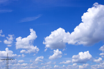 Wolken am blauen Himmel mit Strommast