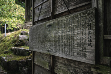 Wooden board filled with Kanji symbols along a hiking trail in Kiso Valley, Japanese Alps, Japan.