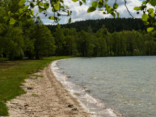 View over Wielewskie lake and beach, sunny day. Blue sky with some white clouds. Kaszuby, Poland