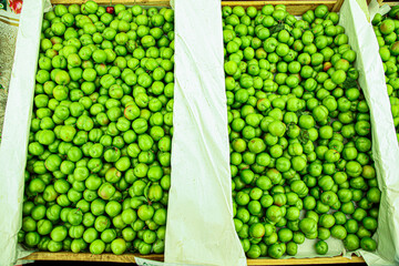 Green cherry plums in market trays