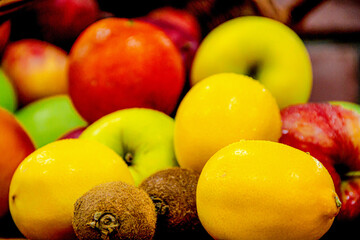 Fresh lemon, kiwies and apples on the ground