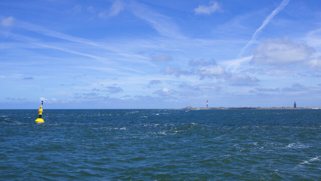 Boje in der Nordsee mit Insel und Leuchtturm