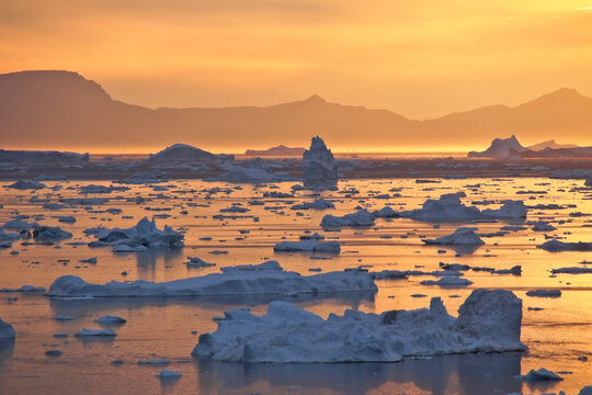 Midnight Sun and icebergs in Disko Bay, Ilulissat, West Greenland - Powered by Adobe