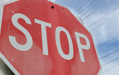 Red Stop Sign that is old and weathered and used.