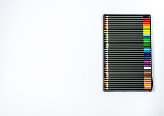 Colored pencils in a case on a white background close-up with place for text.