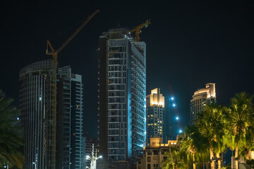 Fototapeta premium New high rise building construction site in Dubai at night. Fast Dubai development concept.