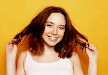 Beautiful happy girl touches her hair.