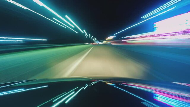Time lapse of driving a car in the city at night. The camera on the hood of the car. Hyperlapse in the evening in the center of the city on the highway. Abstract soft glowing lines.