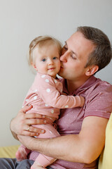Happy family in pink pajamas in play  children's room. Little girl with his father. Good morning of Dad and infant daughter in sleepwear. Family weekdays traditions. Relationship with love
