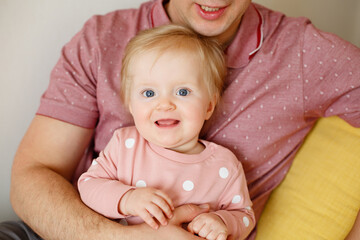 Happy family in pink pajamas in play  children's room. Little girl with his father. Good morning of Dad and infant daughter in sleepwear. Family weekdays traditions. Relationship with love