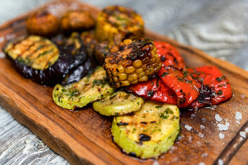 Various tasty grilled vegetables and mushrooms on rustic background