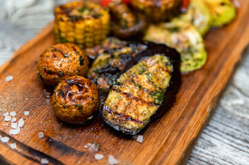 Various tasty grilled vegetables and mushrooms on rustic background