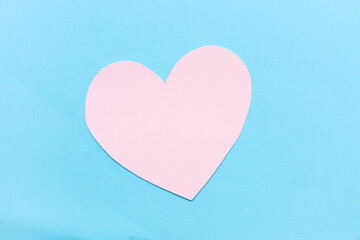 Pink Paper Heart Beat shape on blue background.