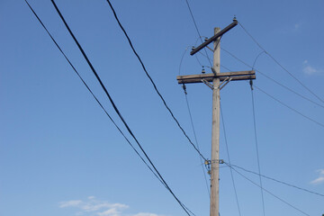 high voltage power lines against blue sky