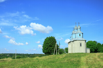 Fototapeta na wymiar Church on a hill on the outskirts of the village. Christian temple landscape in Russia. Stock photo background