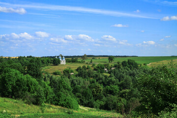 Fototapeta na wymiar Church on a hill on the outskirts of the village. Christian temple landscape in Russia. Stock photo background