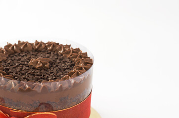Chocolate cake with granulated topping and red bow isolated half view on side