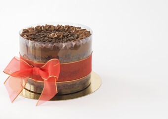 Chocolate cake with granulated topping and red bow isolated full view on side
