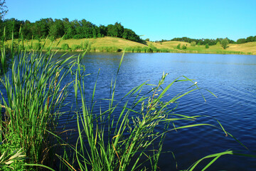 Beautiful river in the highlands in summer. Lake in an ecologically clean park reserve on a background of hills. A pretty landscape in the spring. Stock photo for design