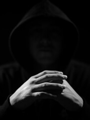 Low key photography, crossed hands of a raper 