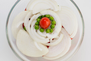 Organic onion salad with cherry tomatoes and peas, zenith view