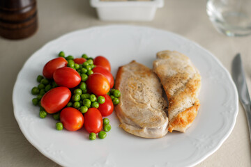 chicken filet with cherry tomatoes and peas