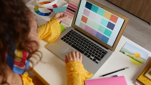 African-American designer working on laptop at home