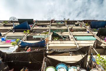 Low angle view of flat in slum against cloud sky