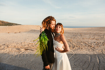 A trendy an attractive blonde bridegrooms in a beach 