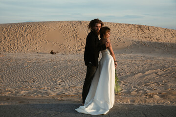 A trendy an attractive blonde bridegrooms in a beach 