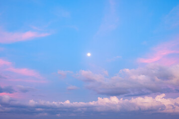 Full moon in the pink sky with clouds