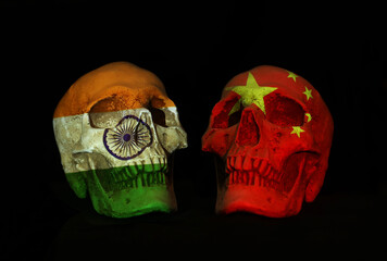 Chinese and india tension over shooting in disputed border territory. Two realsitic looking skulls face off with national flags of both side projected over them.