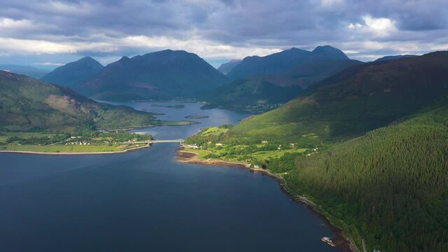 aerial footage of the entrance to glencoe and ballachulish towards loch leven on the west coast of the argyll and lochaber region of the highlands of scotland on a clear blue sky summer day