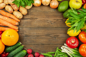 Flat lay of seasonal fruits,vegetables and herbs.Summer food concept. Healthy life and vegetarian,vegan,diet, clean food ingredients. Round frame with place for text.Food on a dark wooden background.