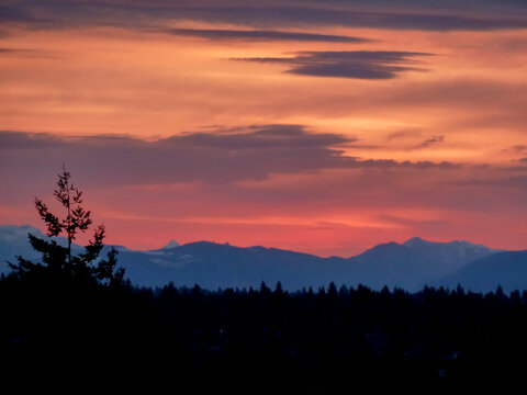 Silhouette of Cascade Mountain Range in Washington State with dark colorful sky above the Cascades.