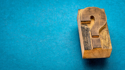 question mark - vintage letterpress printing block on blue handmade rag paper, question, doubt or...